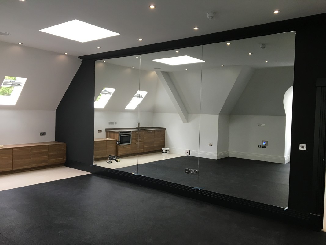 Frameless glass wall dividing loft conversion in Berkhamsted